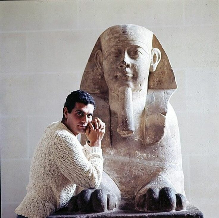Omar Sharif in knitwear by an ancient egypt sculpture